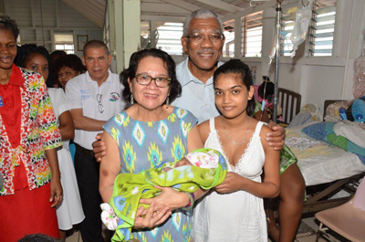 President David Granger and First Lady Sandra Granger posing with Herstelling mom Cassie Baksh and her new baby