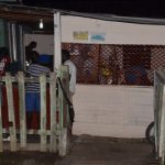 IN THE DARK: Residents at Friendship Buxton hang out at their only ‘backdam’ shop way down Friendship Road last night (Delano Williams photo)