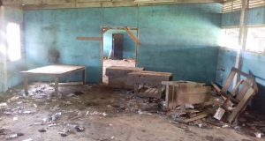 Work benches and garbage among animal dung in a section of the condemned Industrial Arts Complex  