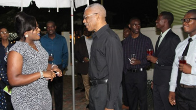 President David Granger shares a light moment with Simona Broomes Jnr, one of the overseas-based Guyanese students who was at the event on Monday evening (Ministry of the Presidency photo)