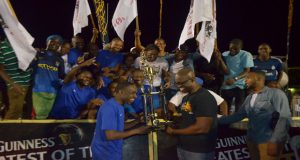 Sparta Boss’s Devon Millington is elated as he receives the Georgetown title of the Guinness Greatest In Da Street from Guinness Brand Manager Lee Baptiste, while the team shares the moment. (Cullen-Bess Nelson Photos)
