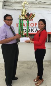 Justice Cecil Kennard (left) accepts the sponsorship cheque and first place trophy from DDL’s Brands Manager Maria Munroe.