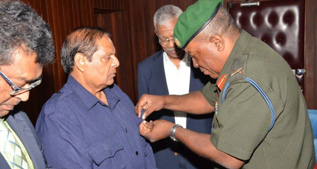 Prime Minister Moses Nagamootoo being conferred with the GDF's Golden Jubilee Commemorative Medal as President David Granger looks on [Ministry of the Presidency photo)