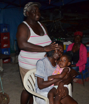 Being comforted by a close family, Payne’s mother Evette [only name given) holds her granddaughter close to her heart as she weeps uncontrollably