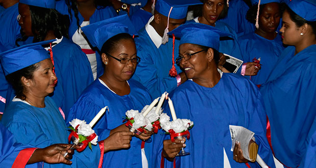 Three of the 310 graduates lighting their candles as a pledge to follow in the footsteps of Florence Nightingale