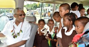 President David Granger takes the driver’s seat of the 'David G. No. 13' while the children get acquainted with their new ride to school 