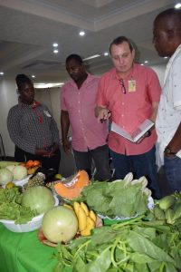 (From left) Logistics personnel Nichola Scott and Troy Semple inspect a vendor’s display with Camp Services Manager Michael Herpel and Security Coordinator Wreford Johnson