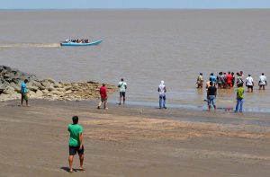 Taxi drivers and relatives move closer to the water as the boat arrives from Corriverton, Berbice
