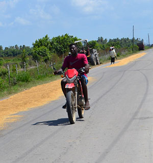 A motorcyclist passes along the roadway near Zambia