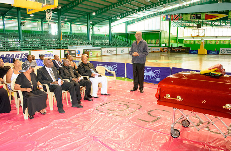 Former Presidential Adviser on Empowerment Odinga Lumumba (extreme right) offers his tribute to Maurice `Bizzy’ Boyce at the Cliff Anderson Sports Hall yesterday (Samuel Maughn photo).