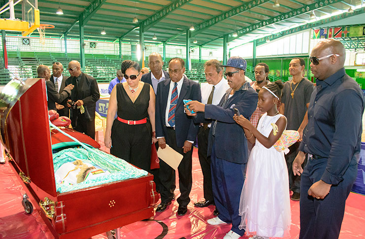 Georgetown’s Mayor Patricia Chase-Green (4th left) pays her respects to the late Maurice `Bizzy’ Boyce at the Cliff Anderson Sports Hall yesterday (Samuel Maughn Photo).