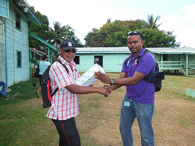 GWI’s Executive Director of Project Implementation & Partnership Building, Ramchand Jailal (right) hands over a Lifesaver filter to Mr. Reid, an elderly resident of Warawatta