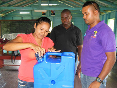 GWI officials look on as a resident tries using a filter for the first time