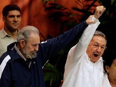 Former Cuban leader Fidel Castro (L) holds up the arm of his brother, Cuba’s President Raul Castro, during the closing ceremony of the sixth Cuban Communist Party (PCC) congress in Havana in this April 19, 2011 file photo. (REUTERS/Desmond Boylan/File Photo)
