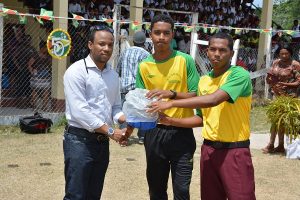 Mr. Jermaine Figueira, Member of Parliament, presents a quantity of sporting gear to members of one of the sports club in Kwakwani Upper Demerara-Berbice (Region 10).