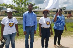 Taking the salute!  Deputy Head Teacher Dion David (left), Former Head Teacher Gloria Britton, Mayor of Linden Carwyn Holland (centre) and teacher Sterling Laflarge (right) preparing to lead the march 