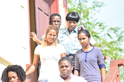 Shamell Inderally [in white] is the mother of the alleged mastermind, Marcus Brian Bisram, while Marian Lionel [in stripe blue top] is the granddaughter of Harrypaul Parsram