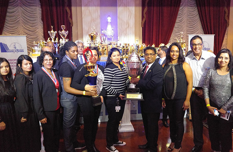 Chief Financial Officer of the SCA, Vish Jadunauth, presents the Caribbean Wave-sponsored winners’ trophy to Kaisoca captain Mahwish Khan in the presence of other teammates.