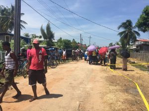 Residents gather outside the dead woman's home