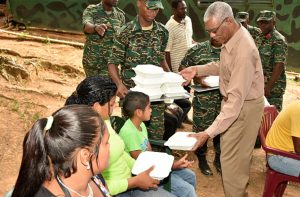 President Granger serving lunch to some of the villagers who were present at the event 