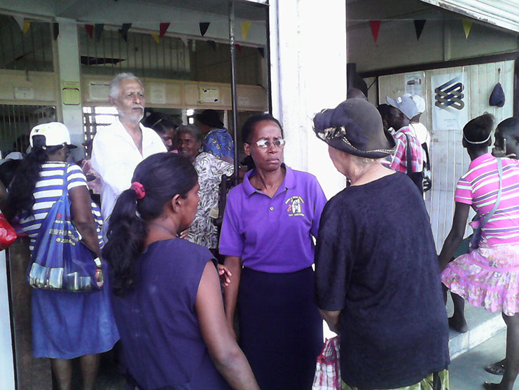 Social Development Officer Patricia Lynch interacts with the elderly at New Amsterdam Post Office