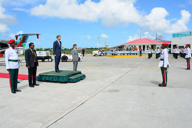 Prince Harry is invited to inspect the Guard of Honour at the Eugene F. Correia International Airport just before his departure