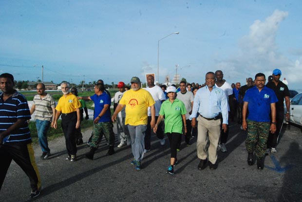 President Donald Ramotar seems to be making good time as the
march proceeded east along  the Seawall Road and into the Rupert Craig Highway on its way
journey’s end,  the University of Guyana’s Campus at Turkeyen.  Keeping pace with him are
First Lady, Mrs. Deolatchmee Ramotar , and Prime Minister Mr. Samuel Hinds, third and
second right respectively (Photo by Cullen Bess-Nelson)