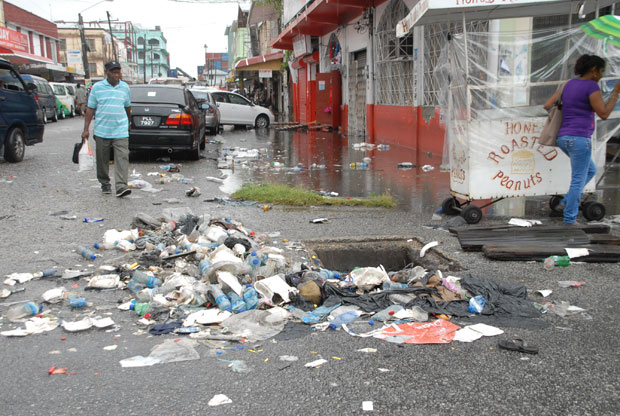 On Avenue of the Republic:   An attempt was made to clear this blocked manhole, but businesses in the background remained closed.
(Photo by Sonell Nelson)