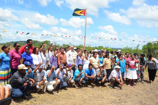 President Donald Ramotar (centre) Minister of Housing and Water Irfaan Ali (far left in red shirt) and Minister of Amerindian Affairs Ms. Pauline Sukhai (in front of Minister Ali) with proud home owners at Kwatamang displaying their keys  (Adrian Narine photo)