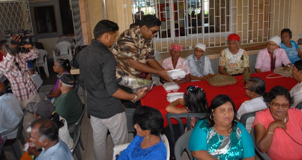 Minster Irfaan Ali distributing lunch to  senior folk he hosted yesterday at the PPP’s office at Leonora