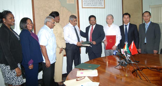 Minister Ashni Singh, GRA Head Kurshid Sattaur, with Chinese Ambassador to Guyana Zhang Limin on his left, and other officers.