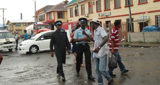It’s still early days yet , but police maintained a tight presence yesterday despite the inclement weather  around the Stabroek Market area as the Christmas spirit slowly gains momentum (Photo by Cullen Bess-Nelson)