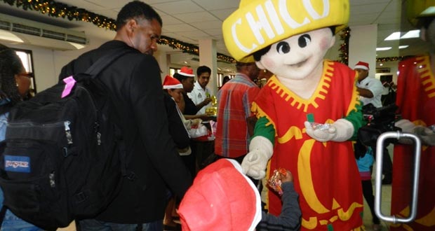 The ‘Chico man’ smiles as a passenger samples one of Edward B. Beharry’s products at the Cheddi Jagan Airport on Monday