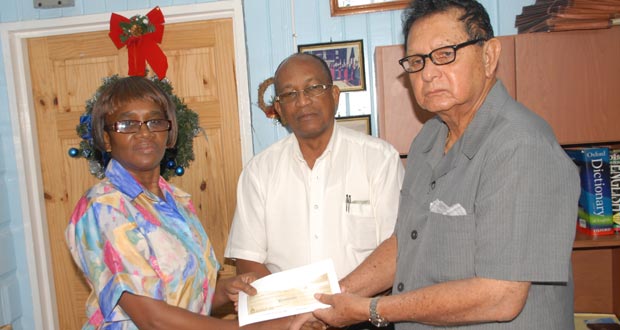 Justice Cecil Kennard (right) accepts the sponsorship cheque from Continental Group of Companies Personnel Assistant Sharon Blackman in the presence of Company Secretary Percival Boyce Jr. (Photo by Sonell Nelson)