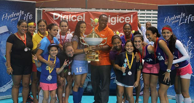 GCC Tigers’ captain, Sonia Jardine (centre), accepts the Diamond Mineral Water Int’s Indoor Hockey Festival first place trophy from Digicel’s Marketing executive, Gavin Hope.