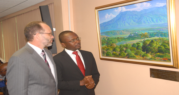 CARICOM Ambassador Irwin LaRocque and Haitian Ambassador Peterson Noel look at a painting of a landscape in Haiti, a gift to CARICOM from President Michel Martelly (Photo by Snnell Nelson)