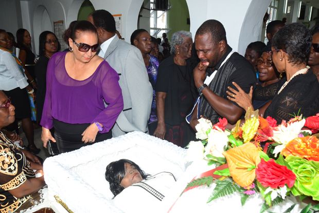 John Beveney, driver of the National Library bus, weeps as he pays his final respects to a beloved former boss. (Photos by Adrian Narine)