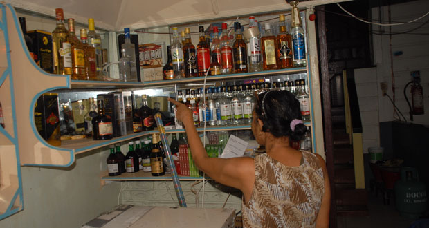 Dhanmatti Ramjass as she points to the spot in the bar where several bottles of liquor were taken by the robbers, who stormed her Pools Bar Wednesday night. (Sonell Nelson photo)