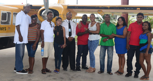 The five couples pose with the pilot before departure from the Ogle International Airport