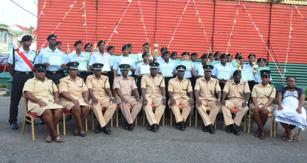 The 24 Assistant Prison Officers (APOs) pose with their certificates and trophies, flanked by senior members of the GPS (seated), yesterday following the ceremony.