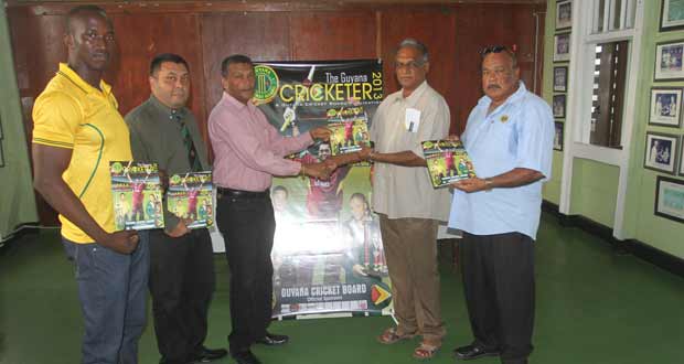 Here you go, Mr Director! Officially, Secretary of the GCB Anand Sanasie (3rd from left) presents Director of Sport Neil Kumar with a copy of the Guyana Cricketer, while from left, Rayon Griffith, Rajendra Singh and Fizul Bacchus proudly display a copy of the Magazine. (Photo by Sonell Nelson)