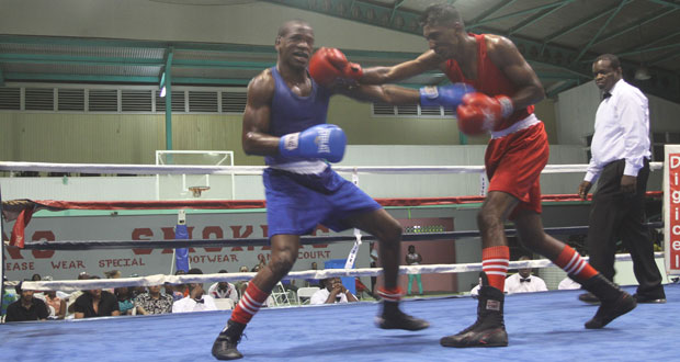 Imran Khan (right) connects to the jaw of his Guyanese counterpart Clairmont Gibson with a straight right in the final of the 60kg division which he won. (Sonell Nelson photo)