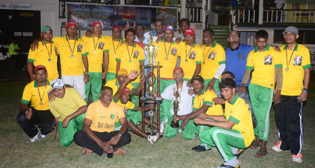 We are the champions! The victorious Wolf Warriors team and their supporters strike a pose with the Georgetown Softball Cricket League Inc. inaugural Republic Cup trophy, after their enthralling seven-run victory over Trophy Stall last Sunday night. (Photo by Adrian Narine)