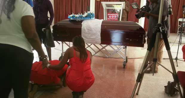 The coffin bearing the body of Claud Derrick Mc Pherson as family members wept
