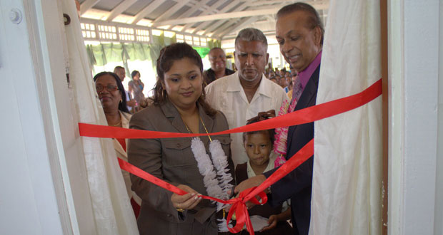 Minister of Education, Ms Priya Manickchand (left) helps former student and philanthropist, Mr. Trevor Subryan with the ceremonial cutting of the ribbon to formally declare the computer laboratory at Bath Primary School open
