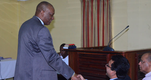 APNU’s Joe Harmon exchanges a handshake with Attorney General Anil Nandlall on arrival at the COI hearings yesterday. In photo, at right, is Home Affairs Minister Clement Rohee.