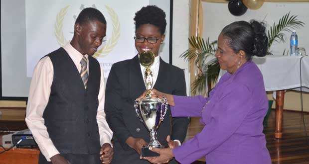 Dr. Carol Bishop (right) presenting the trophy for the Prof. Aubrey Bishop Annual Moot Competition to law students Sherrie Hewitt and Kevin Morgan