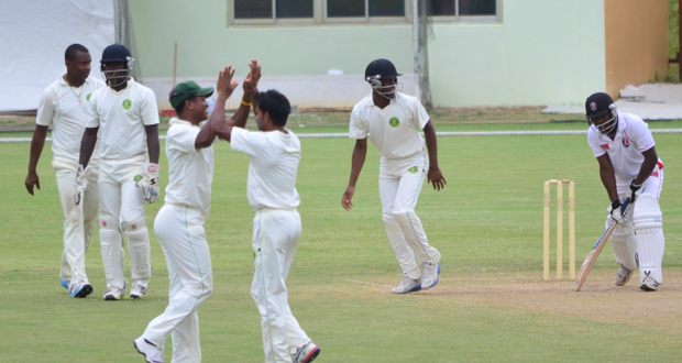 Well done Bishoo! Skipper Leon Johnson high five his leg spinner Devendra Bishoo, after he had Jason Mohammed caught by Zaheer Shadir (not in picture).  Also in picture are wicketkeeper Anthony Bramble, Christopher Barnwell and Shimron Hetmyer. (Photo by Adrian Narine)