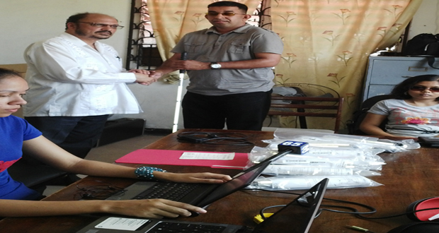 Minister of Health Dr. Bheri Ramsaran as he presented canes to Ganesh Singh of the Guyana Society for the Blind, yesterday. (Michel Outridge photo)