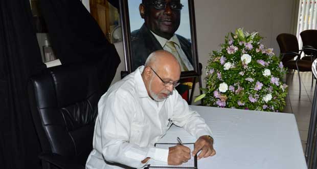 President Donald Ramotar signing the Book of Condolence for former Bank of Guyana Governor Lawrence Williams, yesterday